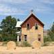 Wood House with hay Bales in front of it