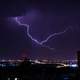 Lightning coming out of the clouds above the city