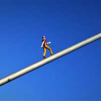 Man Figure walking towards sky on pole