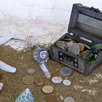 Treasure Chest with Coins in the Sand