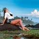 attractive-woman-lying-on-the-rock-near-the-seashore