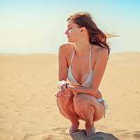 beautiful-young-woman-on-beach-in-white-bikini