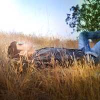 boy-laying-down-in-the-sun-looking-up-in-the-grass