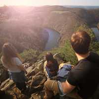 family-of-people-looking-at-river-landscape-below