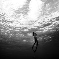 Female swimmer surfacing in the open with fins