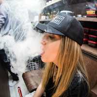 girl-blowing-out-smoke-from-a-pipe