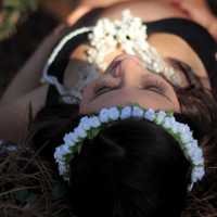 girl-laying-down-in-pine-needles-with-white-flowers