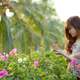 girl-looking-at-flowers-and-thinking