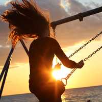 girl-on-swings-at-sunset