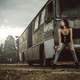 girl-sitting-on-broken-down-bus-in-black-dress-and-jeans