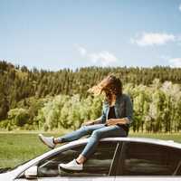 girl-sitting-on-car-with-wind-blowing-through-hair