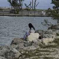 girl-sitting-on-the-rocks-of-the-shoreline