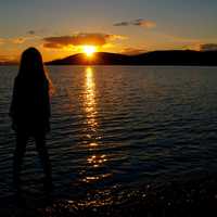 girl-staring-across-the-lake-into-the-sunset