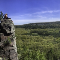 Girls sitting on a rock ledge Panoramic