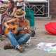 Guitar Player sitting down and street playing