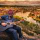 guitarist-playing-while-overlooking-city