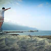 Guy standing on rock pretending to fly