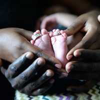 hands-hold-baby-feet-with-rings