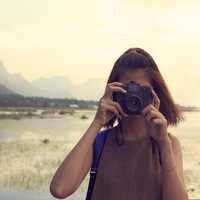 Hipster Traveler with backpack and taking photo of amazing lands