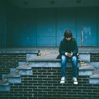 Kid sitting on a platform on a wall