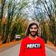 man-in-red-shirt-standing-in-a-corridor-of-trees