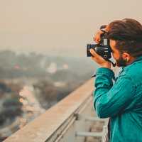 man-in-teal-shirt-shooting-a-photo