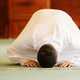 Man in white praying on the ground