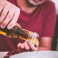 man-pouring-oil-onto-a-plate