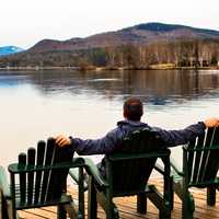 man-sitting-in-the-chair-looking-at-lake-scenery