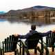 man-sitting-in-the-chair-looking-at-lake-scenery