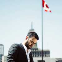 man-standing-under-a-flag-working-on-a-cellphone