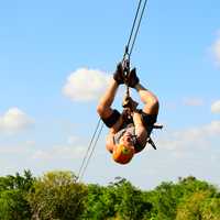 man-zip-lining-upside-down