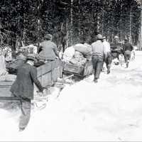 People pulling sleds through the snow 1929