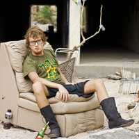 poor-man-sitting-on-couch-on-abandoned-house