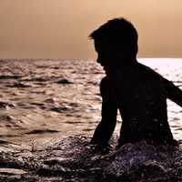 silhouette-of-toddler-splashing-in-the-water