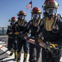 Three Soldiers holding a hose