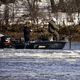 Two people in fishing boat on icy water