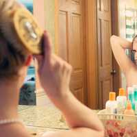 woman-doing-hair-and-makeup-in-bathroom