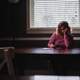 woman-in-pink-shirt-writing-on-paper-on-a-table