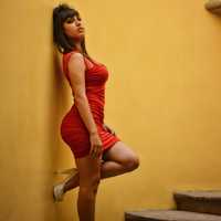 woman-in-red-dress-and-high-heels-next-to-wall