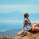 woman-sitting-on-top-of-a-mountain