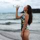 women-by-the-sea-in-bathing-suit-drinking-bottled-water