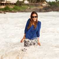 women-in-blue-shirt-standing-in-shallow-surf