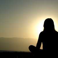 women-meditating-at-sunset