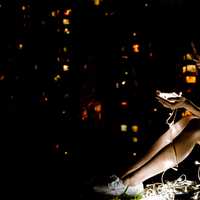 young-women-sitting-at-night-looking-at-small-lights