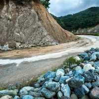 A mountain road with rocks around a bend