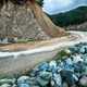 A mountain road with rocks around a bend