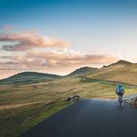 Cyclist with hills and clouds in the distance in Piatra Arsa, Romania