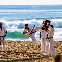 Karate Fighter Jump Kicking on Beach