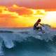 Man surfing a wave at sunset